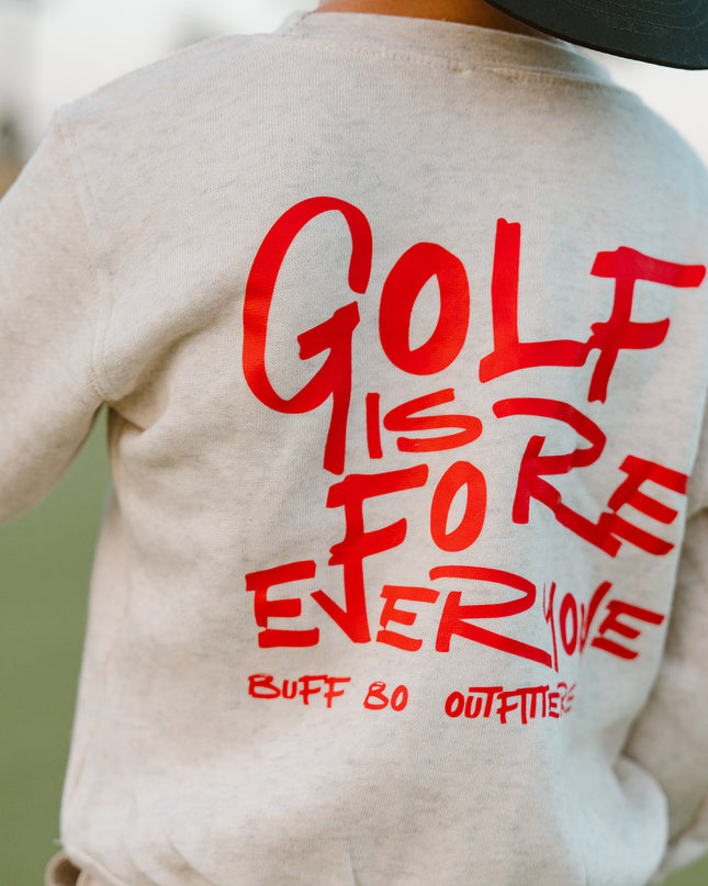Beige sweatshirt with red text 'GOLF IS FOREVER' on the back, worn by a person outdoors.