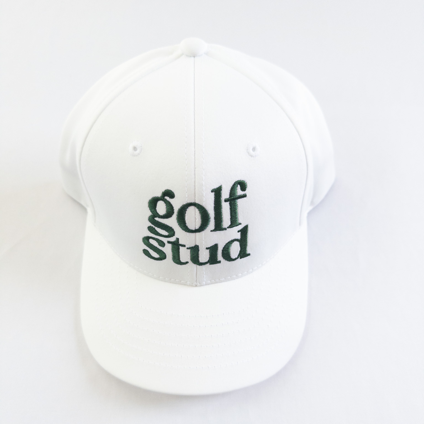 White golf hat with bold green embroidered text reading 'golf stud,' minimalist and stylish golf accessory perfect for young golfers and golf enthusiasts, displayed on a clean white background.