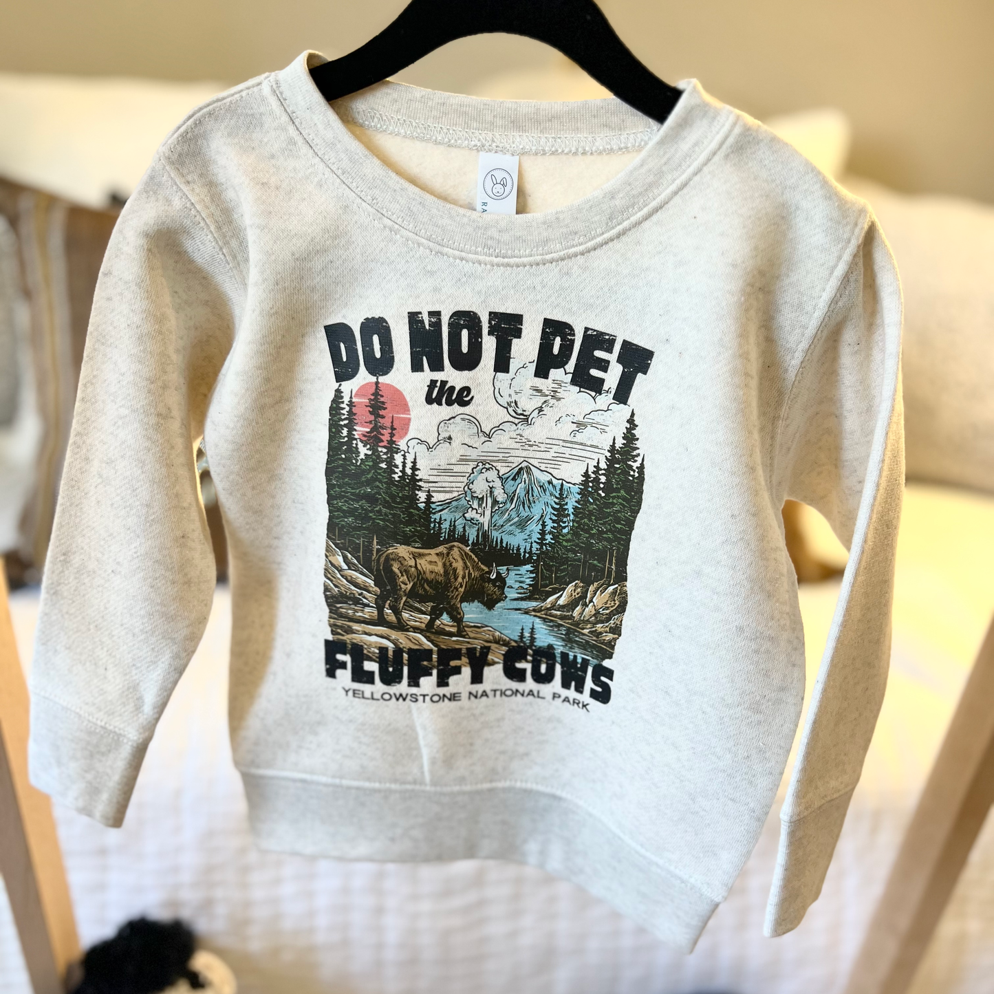 Natural heather toddler sweatshirt featuring the humorous phrase 'Do Not Put The Fluffy Cows'. Perfect for your little one's casual and playful wardrobe.