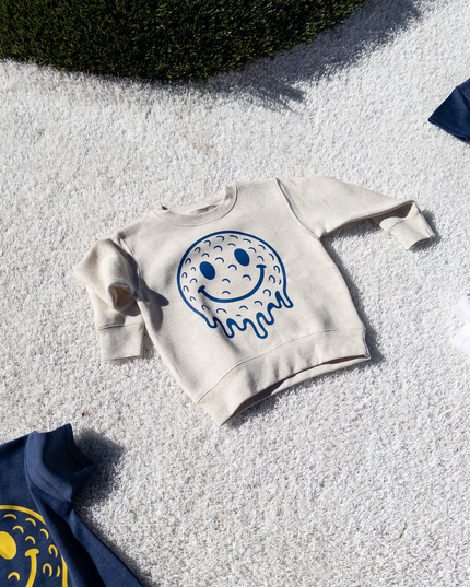 White sweatshirt with smiley face design on a textured surface