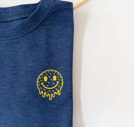 Blue t-shirt with a yellow smiley face design on a white background