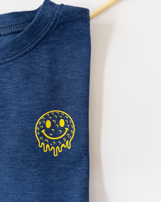 Blue t-shirt with a yellow smiley face design on a white background