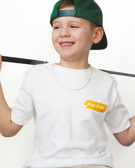 Child wearing a white t-shirt with a logo and a green cap, sitting on a white background