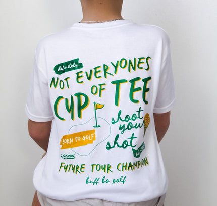 Person wearing a white t-shirt with humorous golf-themed text and a green 'GOLF' cap.