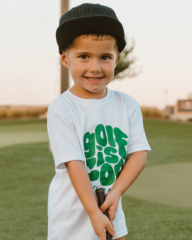 Child holding a golf club on a golf course