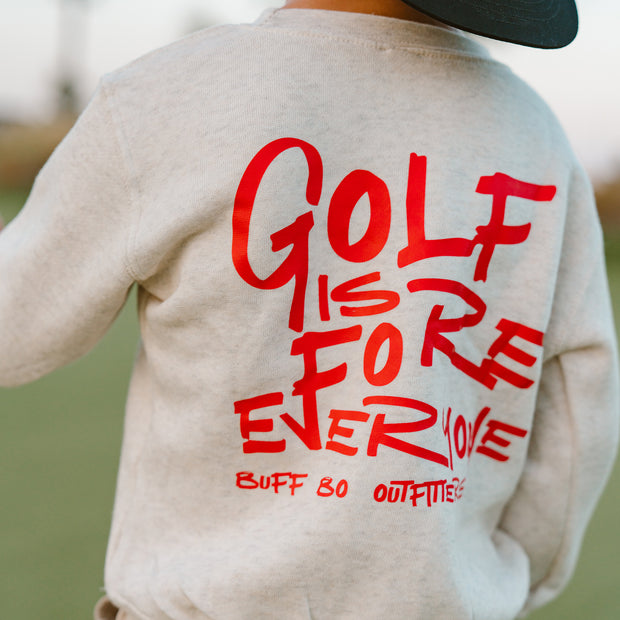 Beige sweatshirt with red text 'GOLF IS FOREVER' on the back, worn by a person outdoors.