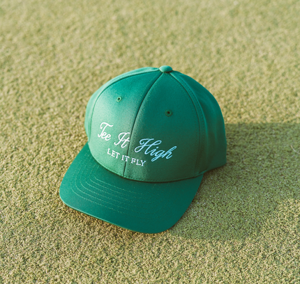 Green cap with text on a sandy surface