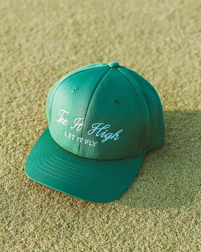 Green cap with text on a sandy surface