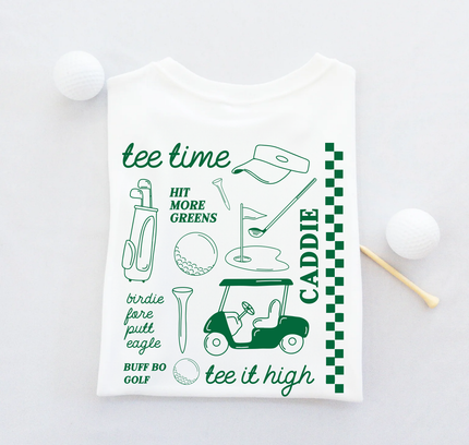 White t-shirt with green golf-themed graphics and text on a light gray background