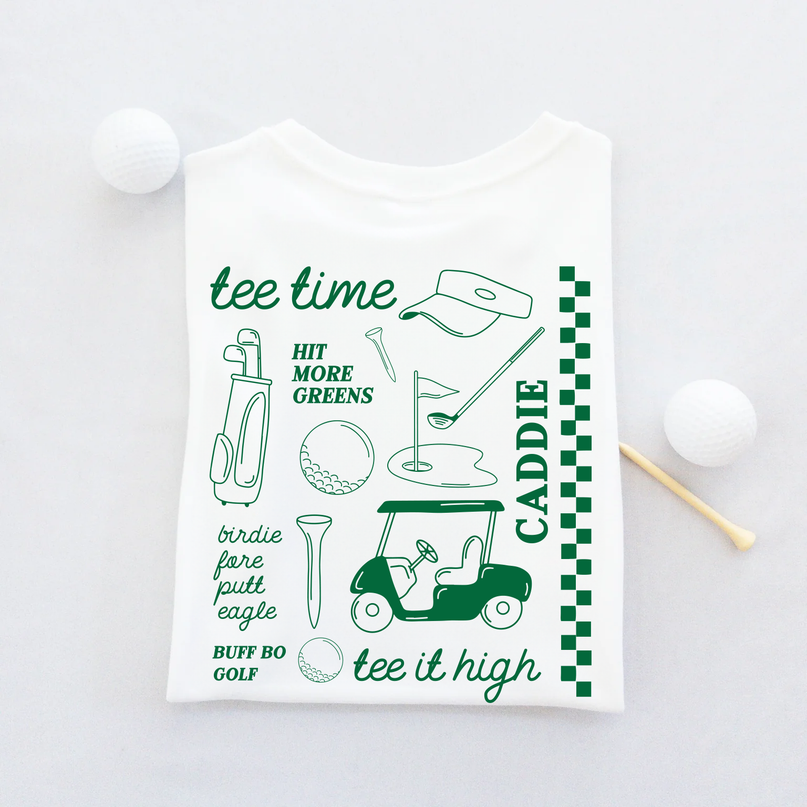 White t-shirt with green golf-themed graphics and text on a light gray background