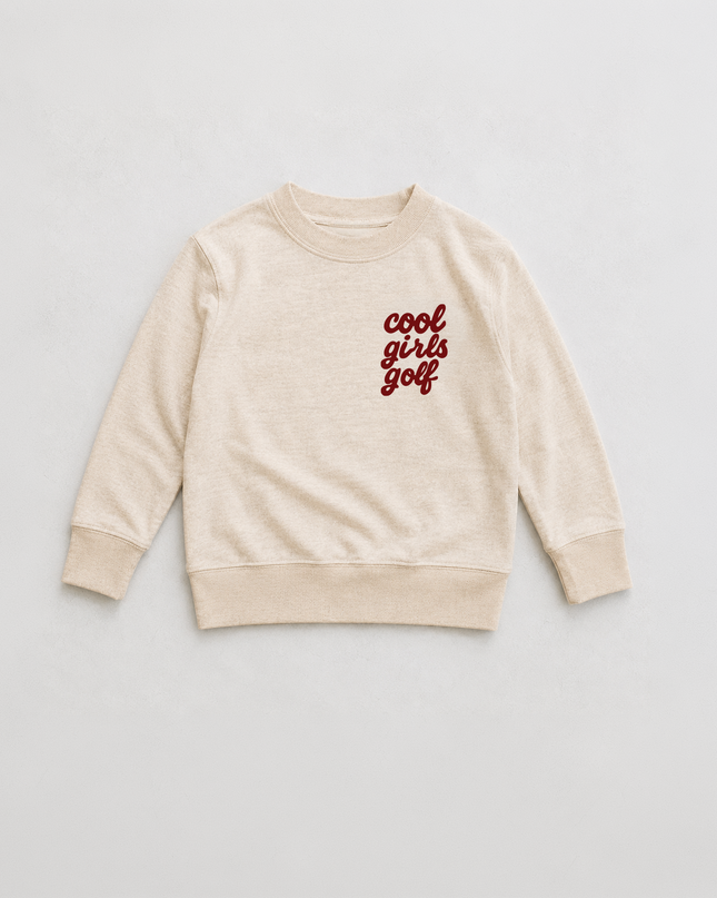 A cream-colored long-sleeve crewneck sweatshirt with 'cool girls golf' printed in red script on the left chest, displayed flat against a light gray background.