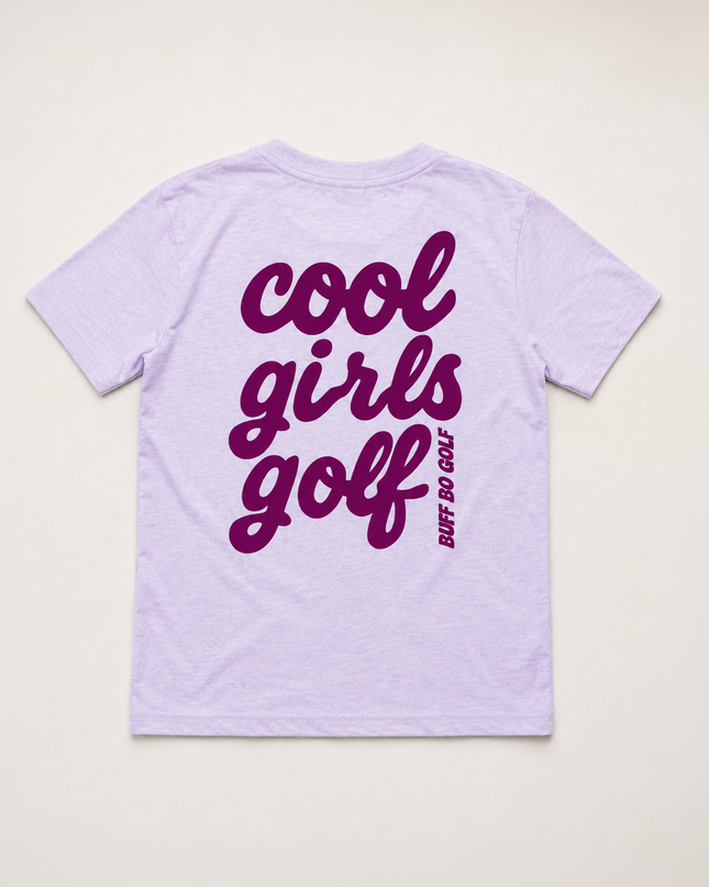 A light lavender short-sleeve t-shirt shown from the back, featuring the words 'cool girls golf' printed in a dark purple script font, with 'BUFF DO GOLF' written vertically in smaller text next to it.