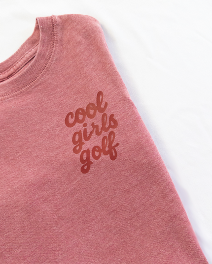 Pink t-shirt with 'cool girls golf' text on a white background