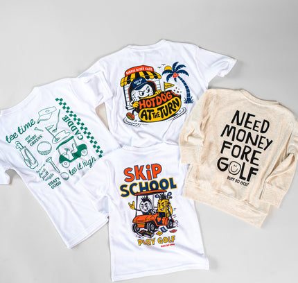 Four golf-themed apparel items arranged on a light gray background: two white graphic T-shirts, one cream graphic sweatshirt, and one white T-shirt shown from the back. The designs feature playful golf illustrations and text including 'HOT DOGS AT VIRNY', 'SKIP SCHOOL', 'NEED MONEY FORE GOLF', and 'too late to start golf'.