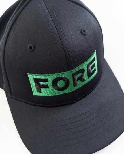 Black golf hat with bold green embroidered patch reading 'FORE,' modern and stylish headwear for golfers, displayed on a simple light background.