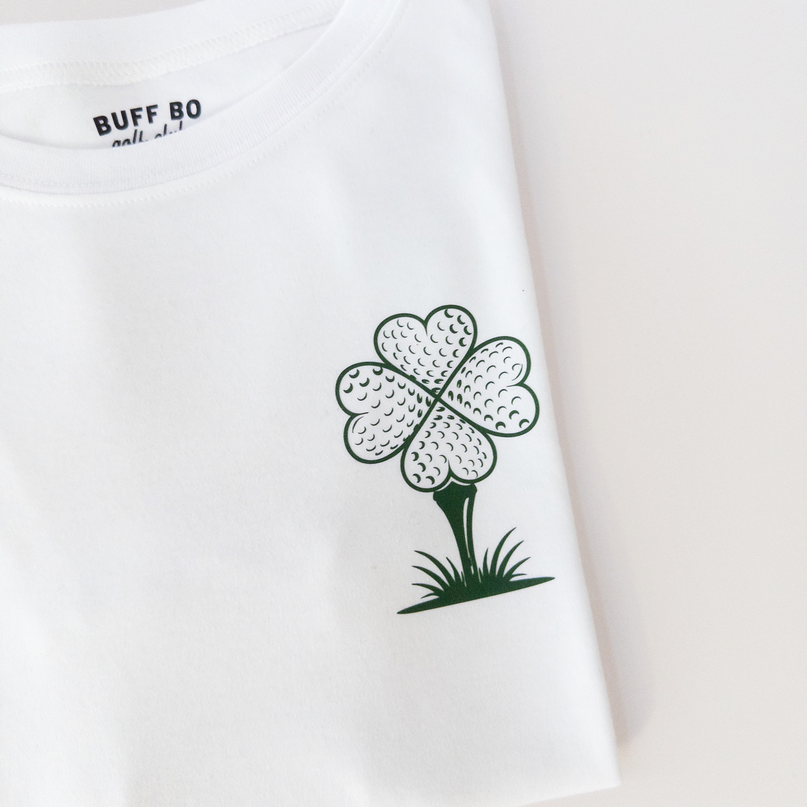 White t-shirt with a four-leaf clover graphic and 'BUFF GO' text on a light background