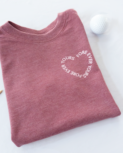 Folded maroon t-shirt with 'Yours Forever' text on a white background