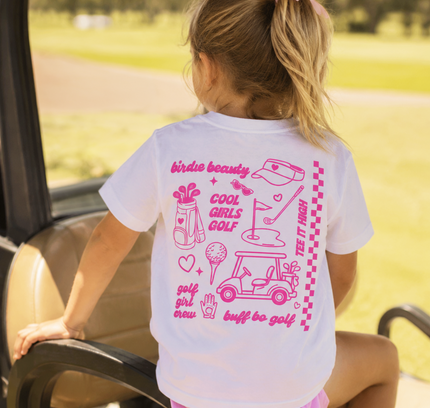 Child wearing a white t-shirt with pink graphics and text, sitting in a golf cart.