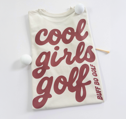 Beige t-shirt with 'cool girls golf' text and golf club on a white background