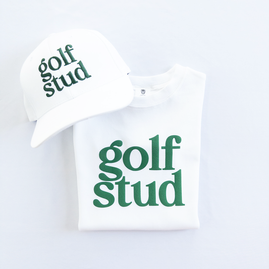 White golf hat and matching white t-shirt featuring bold green 'golf stud' text design, perfect for young golfers and golf-themed apparel lovers, displayed on a clean white background.