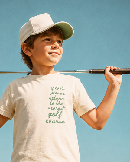 Child holding a golf club on a golf course with a clear blue sky.
