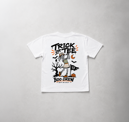 A white short-sleeve t-shirt with a Halloween-themed graphic print on the front, featuring a mummy, 'Trick or Tee', and 'Boo Crew' text, laid flat against a light gray textured background.