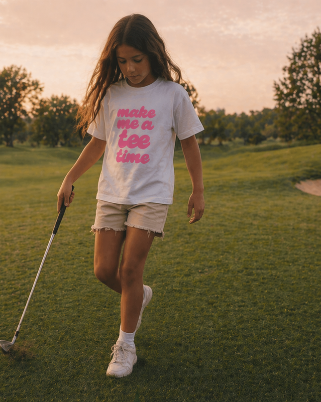 Young girl on a golf course holding a golf club with text on her shirt.