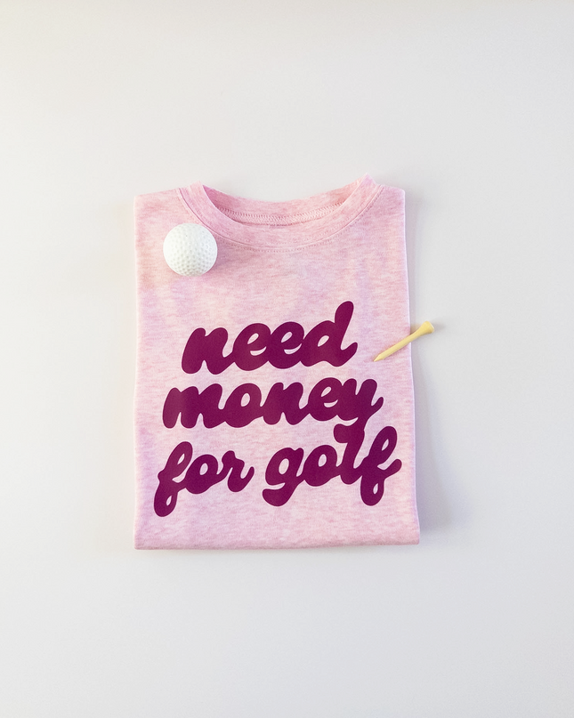 Pink t-shirt with 'need money for golf' text on a light gray background