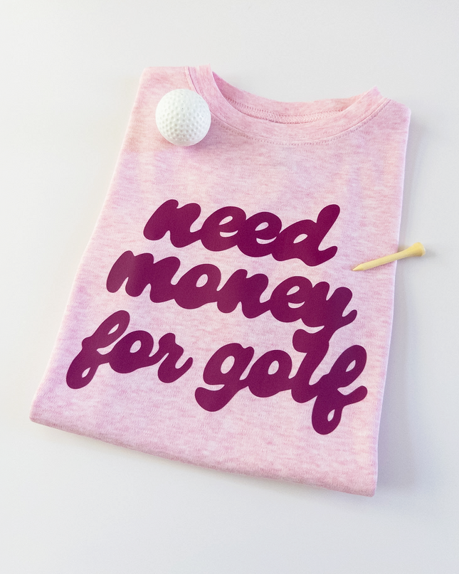 Pink t-shirt with 'need money for golf' text on a white background