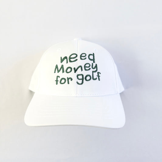 White golf hat featuring playful dark green embroidered text 'need money for golf,' fun and casual headwear for young golfers and golf enthusiasts, displayed on a light neutral background.