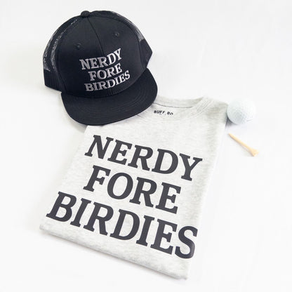Black cap and white t-shirt with 'Nerdy Fore Birdies' text on a white background