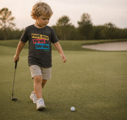 Child on a golf course with a golf club and ball