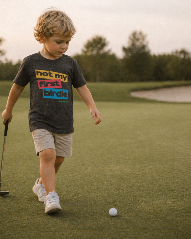 Child on a golf course with a golf club and ball