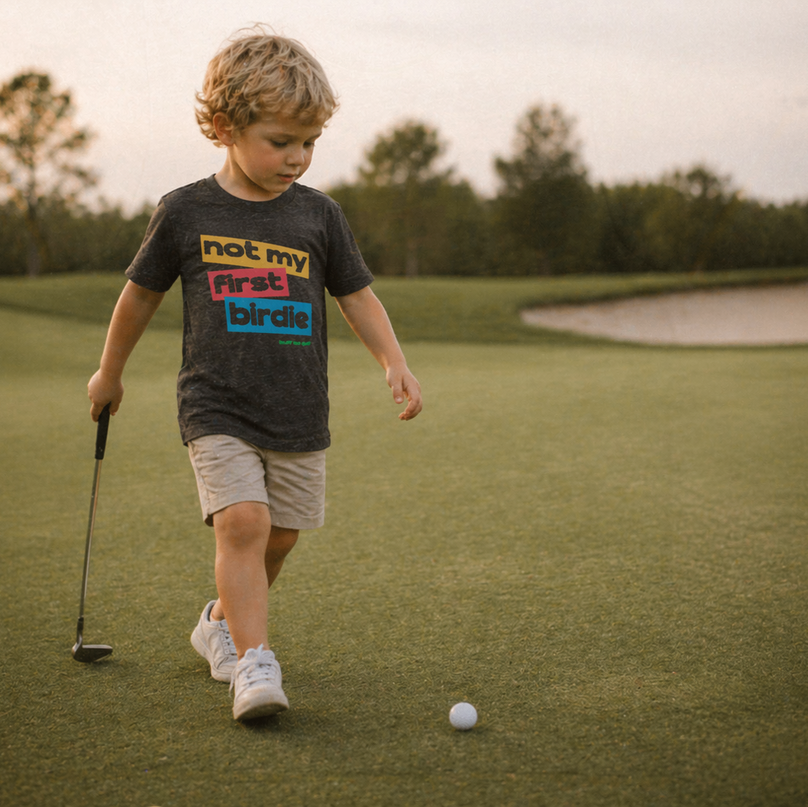 Child on a golf course with a golf club and ball