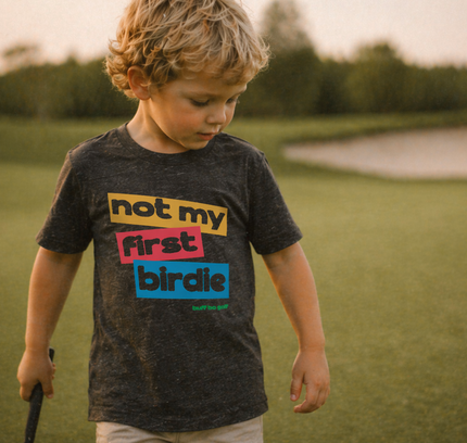 Child wearing a t-shirt with colorful text in an outdoor setting