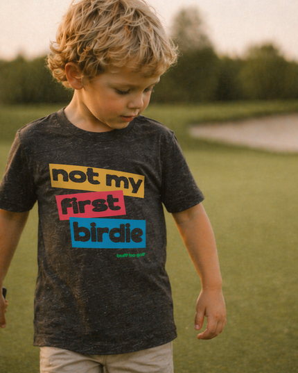 Child wearing a t-shirt with colorful text in an outdoor setting