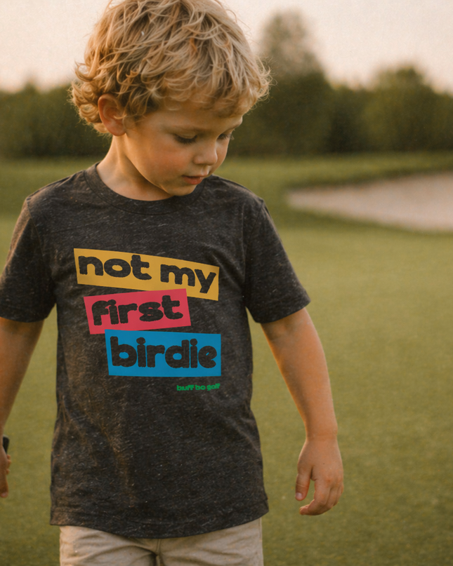Child wearing a t-shirt with colorful text in an outdoor setting