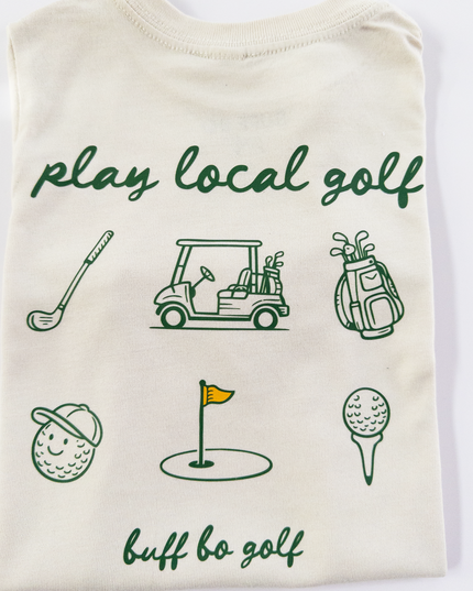 Folded t-shirt with golf-themed graphics and text on a white background