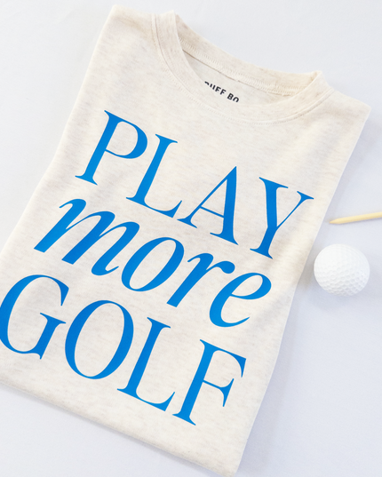 Folded t-shirt with 'PLAY more GOLF' text on a white background