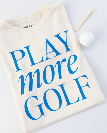Beige t-shirt with 'Play more Golf' text in blue on a light gray background