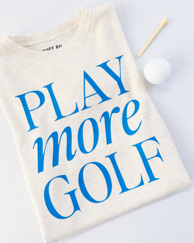 Beige t-shirt with 'Play more Golf' text in blue on a light gray background