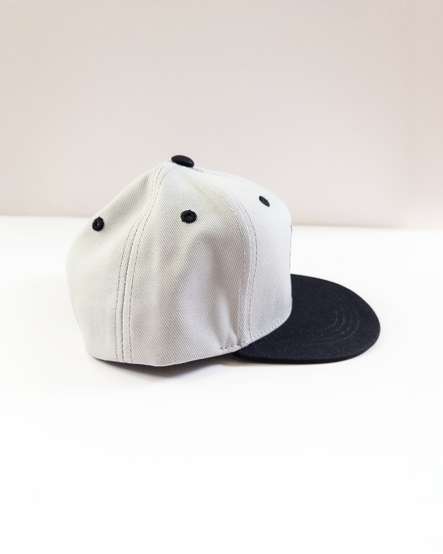 grey cap with black brim on a light beige background