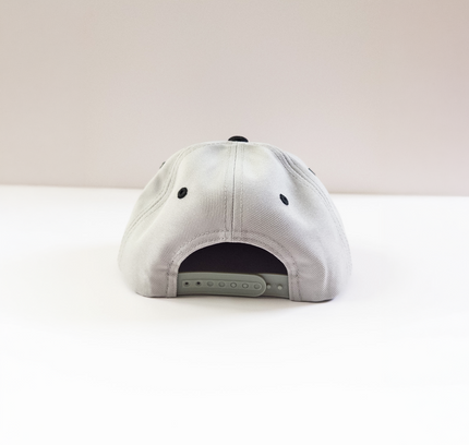 grey cap with black buttons on a light pink background