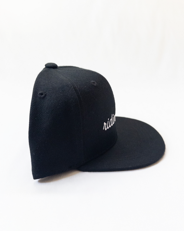 Black cap with 'ridin' embroidered on a white background