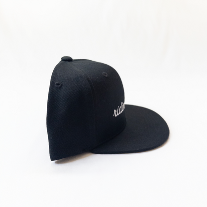 Black cap with 'ridin' embroidered on a white background