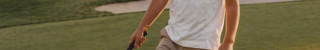 Young boy on a golf course holding a golf club