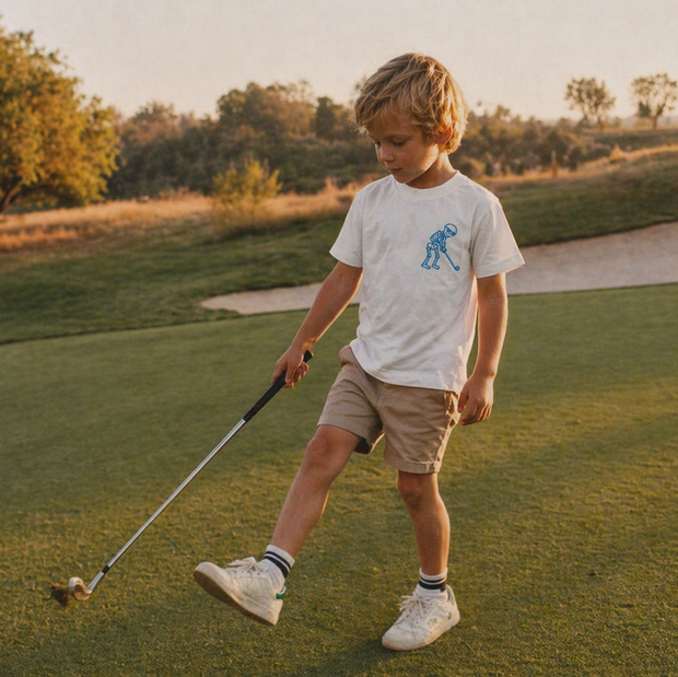 Young boy on a golf course holding a golf club