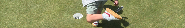 Child playing golf on a green course