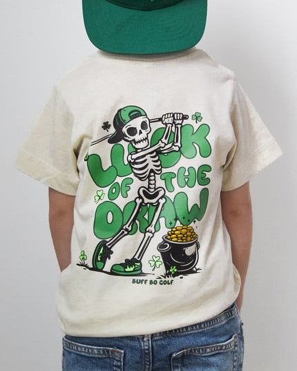 Person wearing a green 'GOLF' cap and a white t-shirt with a skeleton design on a plain background