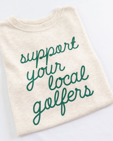 Buff Bo Outfitters' 'Support Your Local Golfers' kids' t-shirt in soft cream. A stylish and comfortable tee celebrating young golfers and the love of the game.